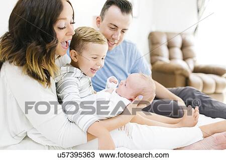 Parents sitting with daughter(0-1 months) and son (4-5) on bed in bedroom View Large Photo Image Stock Image - Parents sitting with daughter(0-1 months) and son (4-5) on bed in bedroom. Fotosearch