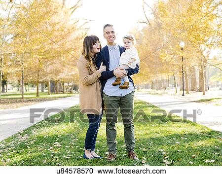 Stock Image - Parents with daughter (12-17 months) in park. Fotosearch