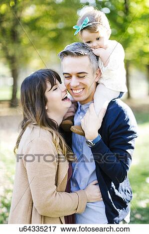 Stock Photo - Parents with daughter (12-17 months) in park. Fotosearch