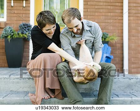 Parents with daughter (12-17 months) sitting in front of house View Large Photo Image Stock Image - Parents with daughter (12-17 months) sitting in front of house. Fotosearch