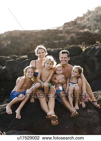 Stock Image - Parents with four children (12-17 months, 4-5, 6-7, 8-9) at beach. Fotosearch