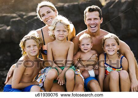 Stock Photograph - Parents with four children (12-17 months, 4-5, 6-7, 8-9) at beach. Fotosearch