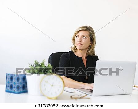 Stock Image - Pensive Mature woman in office. Fotosearch
