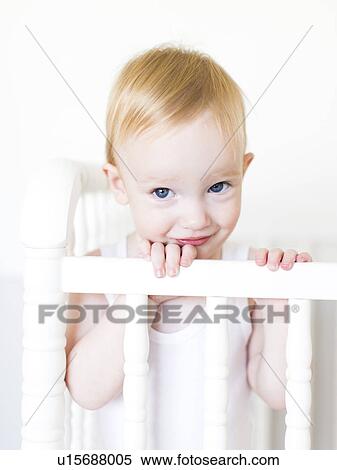 Portrait of baby boy (12-17 months) standing in crib View Large Photo Image Stock Photography - Portrait of baby boy (12-17 months) standing in crib. Fotosearch
