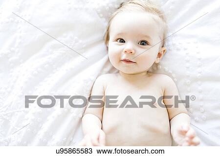 Stock Image - Portrait of baby girl (6-11 Months) smiling, directly above. Fotosearch