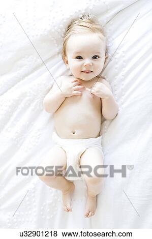 Stock Photo - Portrait of baby girl (6-11 Months) smiling, directly above. Fotosearch
