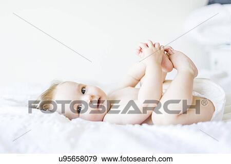 Stock Photo - Portrait of baby girl (6-11 Months) looking at camera and smiling. Fotosearch