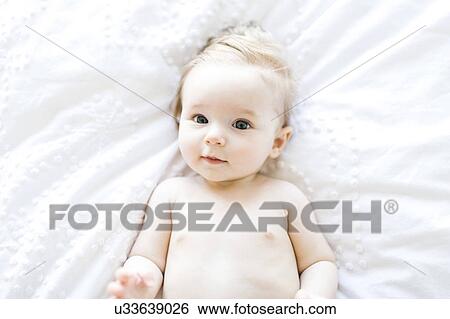 Stock Photograph - Portrait of baby girl (6-11 Months) smiling, directly above. Fotosearch