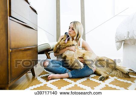 Stock Image - Portrait of blond woman with golden retriever. Fotosearch