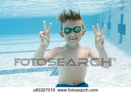Portrait of boy (6-7) gesturing in swimming pool View Large Photo Image Stock Photo - Portrait of boy (6-7) gesturing in swimming pool. Fotosearch