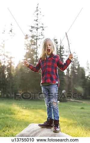 Portrait of boy (6-7) standing on rock in forest View Large Photo Image Stock Image - Portrait of boy (6-7) standing on rock in forest. Fotosearch