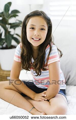 Portrait of content girl (10-11) sitting with legs crossed View Large Photo Image Stock Image - Portrait of content girl (10-11) sitting with legs crossed. Fotosearch