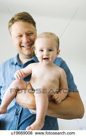 Stock Photo - Portrait of father and baby girl (12-17 months) after bath. Fotosearch