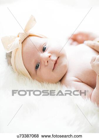 Portrait of girl (0-1 months) with ribbon on head View Large Photo Image Stock Photo - Portrait of girl (0-1 months) with ribbon on head. Fotosearch