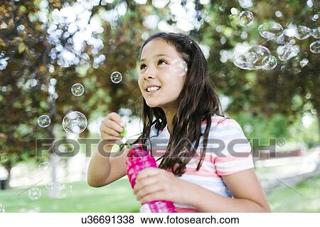 Portrait of girl ( 10-11 ) blowing soap bubbles View Large Photo Image Stock Photo - Portrait of girl ( 10-11 ) blowing soap bubbles. Fotosearch