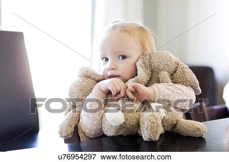 Stock Photo - Portrait of girl ( 12-17 months ) holding stuffed toys. Fotosearch
