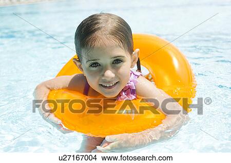 Picture - Portrait of girl (4-5) swimming in inflatable ring. Fotosearch