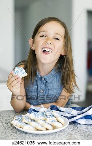 Portrait of girl (6-7) eating cookies View Large Photo Image Stock Photography - Portrait of girl (6-7) eating cookies. Fotosearch