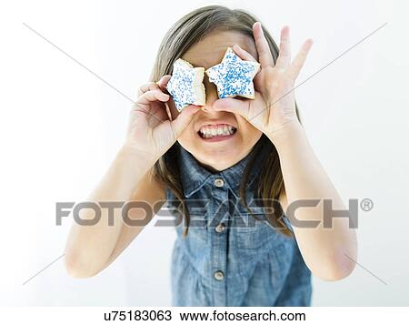 Portrait of girl (6-7) holding cookies in front of eyes View Large Photo Image Stock Image - Portrait of girl (6-7) holding cookies in front of eyes. Fotosearch