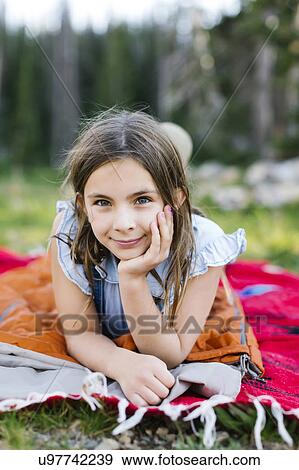 Portrait of girl (8-9) lying on blanket in forest View Large Photo Image Stock Photo - Portrait of girl (8-9) lying on blanket in forest. Fotosearch