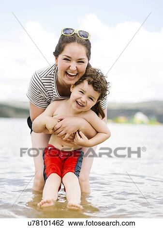 Portrait of laughing mother with son (4-5) wading in lake View Large Photo Image Stock Image - Portrait of laughing mother with son (4-5) wading in lake. Fotosearch