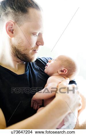 Portrait of man holding his on day son (0-1 months) View Large Photo Image Picture - Portrait of man holding his on day son (0-1 months). Fotosearch