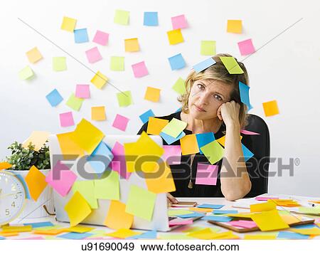 Stock Photo - Portrait of Mature woman at office covered with adhesive notes. Fotosearch