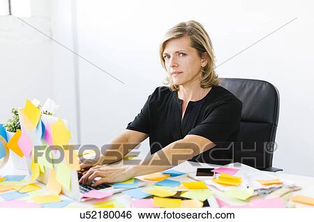 Portrait of Mature woman at office overwhelmed by adhesive notes View Large Photo Image Stock Photograph - Portrait of Mature woman at office overwhelmed by adhesive notes. Fotosearch