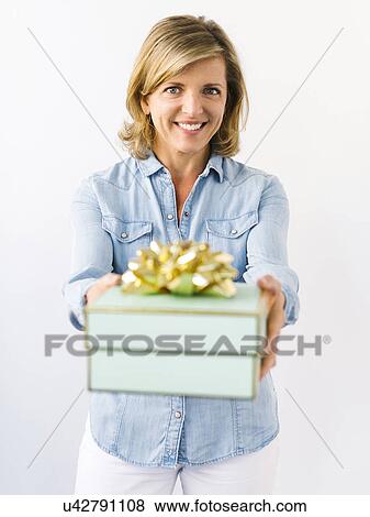 Stock Photo - Portrait of Mature woman giving gift. Fotosearch
