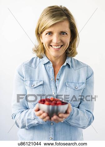 Portrait of Mature woman holding bowl with raspberries View Large Photo Image Picture - Portrait of Mature woman holding bowl with raspberries. Fotosearch