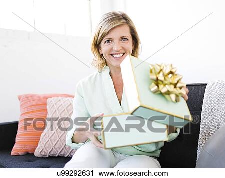 Portrait of Mature woman opening gift View Large Photo Image Stock Image - Portrait of Mature woman opening gift. Fotosearch