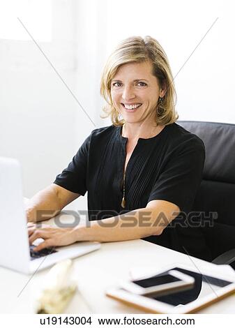Picture - Portrait of Mature woman working on laptop. Fotosearch