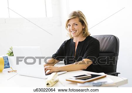 Picture - Portrait of Mature woman working on laptop. Fotosearch