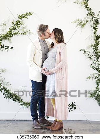 Portrait of men and pregnant woman kissing View Large Photo Image Stock Image - Portrait of men and pregnant woman kissing. Fotosearch