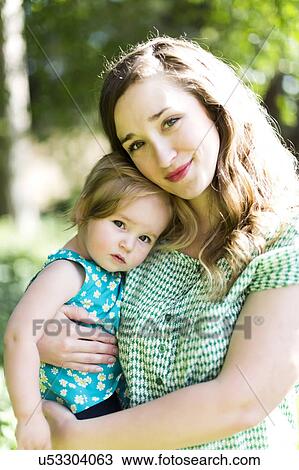 Stock Image - Portrait of mother and baby girl (12-17 months) in backyard. Fotosearch