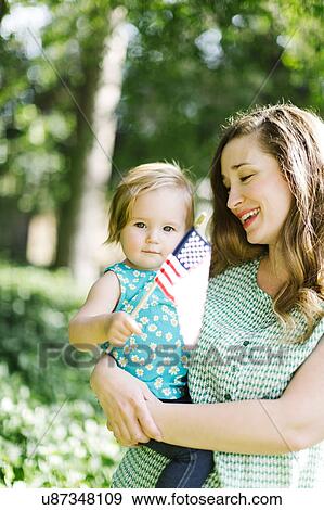 Stock Photo - Portrait of mother and baby girl (12-17 months) in backyard. Fotosearch