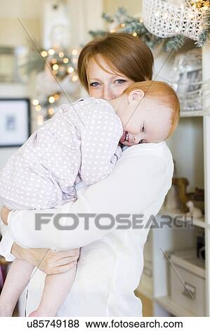 Stock Photo - Portrait of mother embracing daughter ( 12-17 months ). Fotosearch