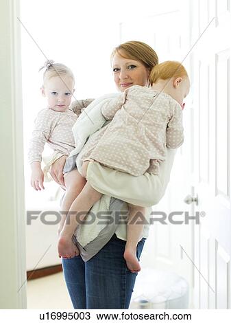Portrait of mother embracing daughters ( 12-17 months ) View Large Photo Image Stock Image - Portrait of mother embracing daughters ( 12-17 months ). Fotosearch