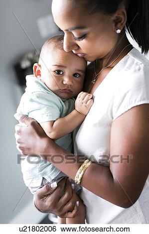 Stock Photograph - Portrait of mother holding baby boy (2-5 months). Fotosearch