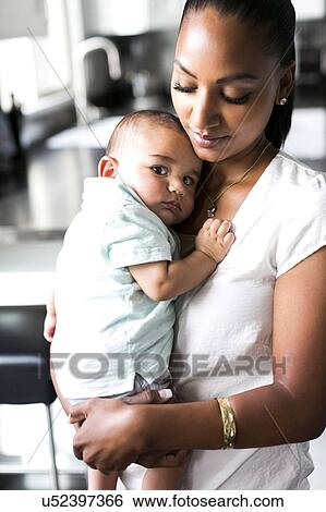 Stock Photograph - Portrait of mother holding baby boy (2-5 months). Fotosearch