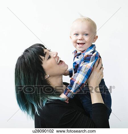 Portrait of mother holding son (12-17 months) against white background View Large Photo Image Stock Image - Portrait of mother holding son (12-17 months) against white background. Fotosearch
