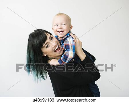 Portrait of mother holding son (12-17 months) against white background View Large Photo Image Stock Image - Portrait of mother holding son (12-17 months) against white background. Fotosearch