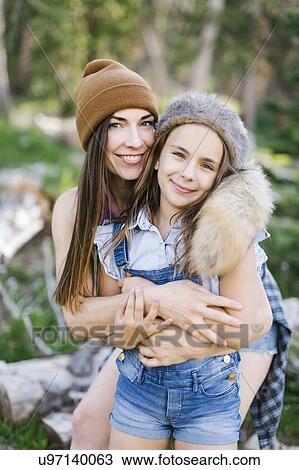 Stock Image - Portrait of mother with daughter (8-9) hiking in forest. Fotosearch