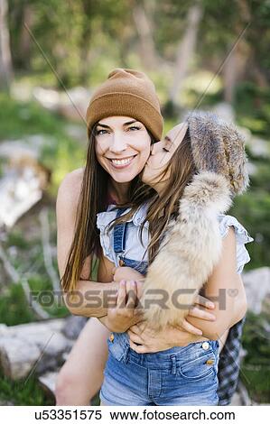 Stock Photography - Portrait of mother with daughter (8-9) hiking in forest. Fotosearch
