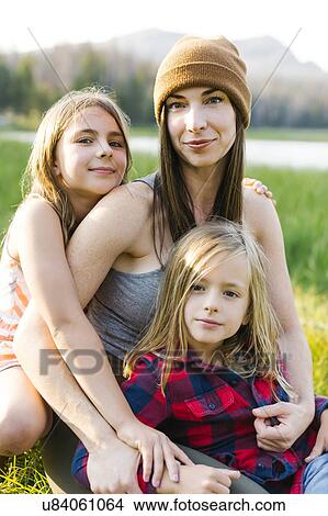 Picture - Portrait of mother with son (6-7) and daughter (8-9) in meadow. Fotosearch