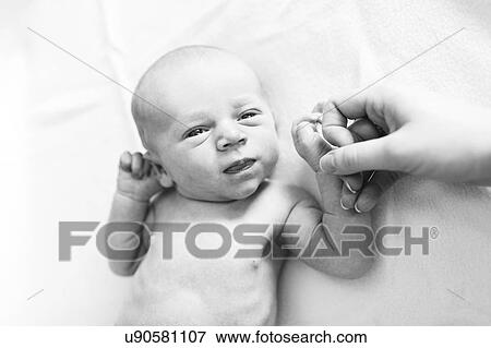 Stock Photo - Portrait of newborn boy ( 0-1 months ) holding mother's hand. Fotosearch