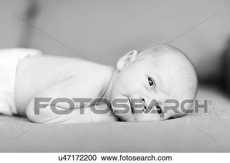 Stock Image - Portrait of one day Baby boy (0-1 months) lying on sofa. Fotosearch