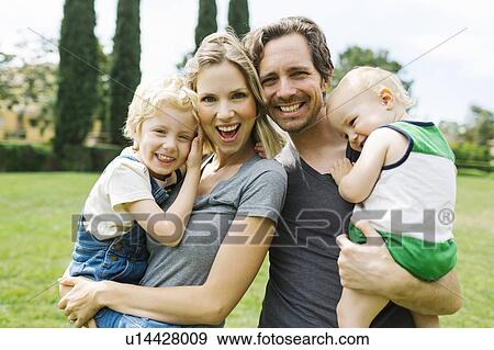 Portrait of parents with sons (12-17 months, 4-5) in park View Large Photo Image Stock Photo - Portrait of parents with sons (12-17 months, 4-5) in park. Fotosearch