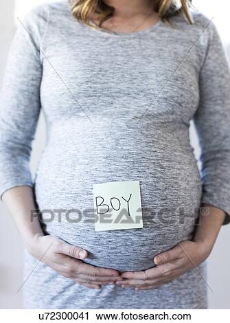 Portrait of smiling pregnant woman with adhesive note on belly View Large Photo Image Stock Image - Portrait of smiling pregnant woman with adhesive note on belly. Fotosearch
