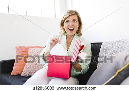 Stock Image - Portrait of surprised Mature woman with christmas gift. Fotosearch